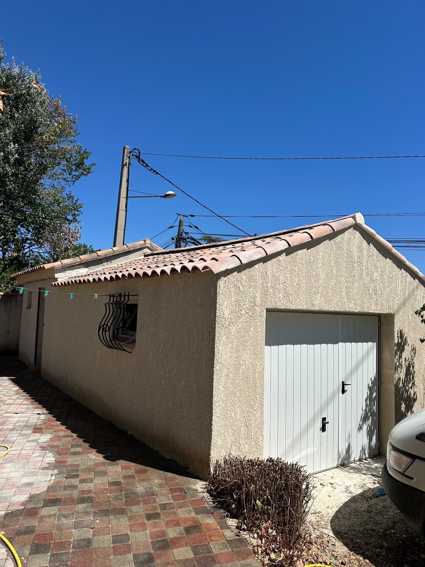 Façade terminée avec enduit frotassé et porte de garage